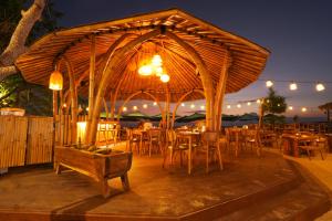 restauracja z drewnianym pawilonem ze stołami i krzesłami w obiekcie Living Asia Sunset Resort w Gili Air