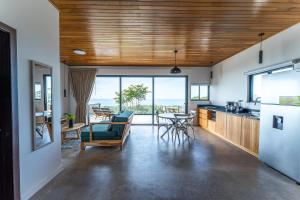 a kitchen and dining room with a view of the ocean at Ocean Apartments- Walk to the beach in Santa Teresa Beach