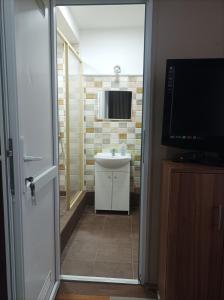 a bathroom with a sink and a mirror at Mátyás Pizzéria, Étterem és Vendégház in Balkány +5 photos