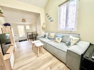 a living room with a couch and a table at Charmante Maison de Ville - Patio - Wifi - Parking gratuit in La Rochelle