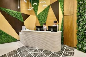 two people sitting at a reception desk with laptops at Hotel YX Lai Chi Kok in Hong Kong