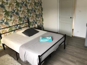 a bed with a blue towel on it in a bedroom at Grande chambre côté jardin in Château-du-Loir