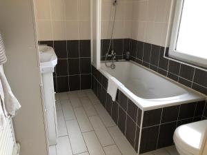a bathroom with a tub and a toilet and a sink at Grande chambre côté jardin in Château-du-Loir