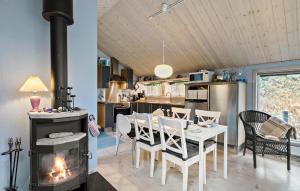 cocina y comedor con chimenea, mesa y sillas en Nice Home In Hobro With Sauna, en Hobro