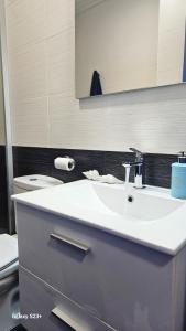 a bathroom with a white sink and a toilet at Apartamento Blue Garrucha in Garrucha