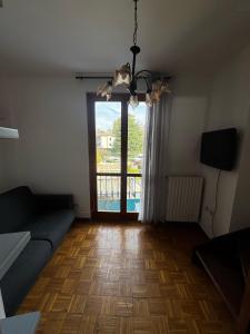 a living room with a couch and a large window at Le camere del Sal8 al Parco in Villasanta