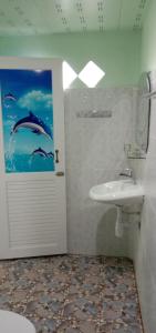 a bathroom with a sink and a door with a picture of dolphins at GREEN LAND Resort in Ban Bang Bao