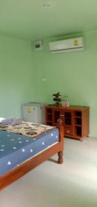 a bedroom with a bed and a wooden cabinet at GREEN LAND Resort in Ban Bang Bao