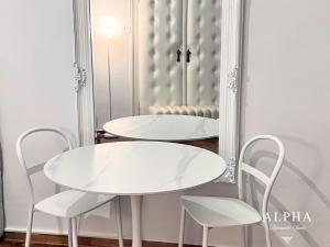 a white table and chairs in front of a mirror at Alpha Romantic Suites Ljubljana in Ljubljana +29 photos