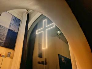 a lit cross on the wall of a church at CHENGDU Liaofan Design B&B Houwu Temple Jinli Twin Suite Ximenqiao Street Morogo White Castle HD Projection LOFT Double Floor Bnb High-Quality Housing in Chengdu