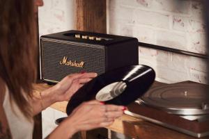 a woman holding a brush next to a radio at CHENGDU Liaofan Design B&B Houwu Temple Jinli Twin Suite Ximenqiao Street Morogo White Castle HD Projection LOFT Double Floor Bnb High-Quality Housing in Chengdu