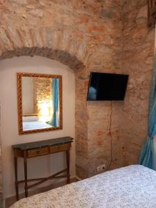 a bedroom with a mirror and a tv on a wall at Tsopela Boutique Hotel in Skiathos