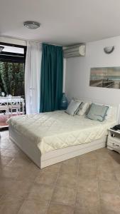 a bedroom with a large bed with a green curtain at Heritage in Oasis Resort Lozenets in Lozenets +21 photos