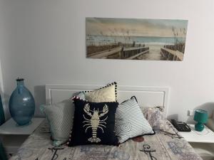 a bed with pillows and a painting on the wall at Heritage in Oasis Resort Lozenets in Lozenets