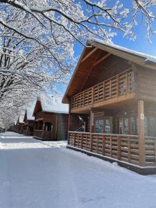 a log cabin with snow on the ground at Raduta Hotel & Restaurant Complex in Bulakhovka