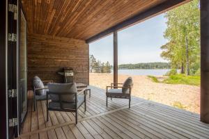 eine Terrasse mit Stühlen und einem Tisch mit Blick auf einen See in der Unterkunft Saunamäki - Frida in Salo