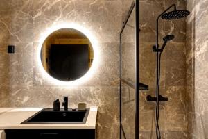 ein Badezimmer mit Waschbecken und Dusche mit Spiegel in der Unterkunft Saunamäki - Frida in Salo + 12 Fotos