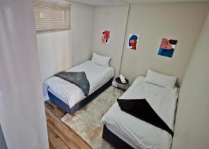 une petite chambre avec deux lits et une fenêtre dans l'établissement Windhoek Kalahari Haven, à Windhoek