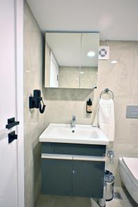 a bathroom with a sink and a mirror at Central location LOFT Apartment in Avcılar