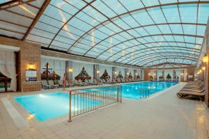 a large indoor swimming pool with a glass ceiling at Kremlin Palace in Lara
