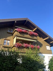 a building with flower boxes on the side of it at LOFTI'S Alpin View Suite in Oberreute