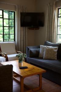 温特顿Berghaven Cottages的客厅配有2张蓝色沙发和1张咖啡桌