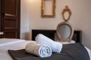 a pile of towels on a bed with a mirror at CHIC ANDREOSSY-COSY-AUTHENTIQUE-WI-Fi-Vélo in Castelnaudary