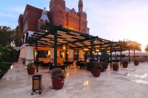 a patio with tables and chairs in front of a building at Kremlin Palace in Lara