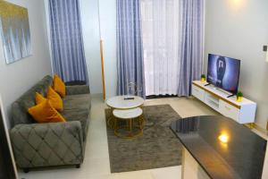 un soggiorno con un divano e una TV di FirstChoice apartments Kampala a Kampala