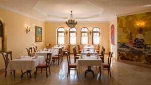 a dining room with tables and chairs and a chandelier at Kremlin Palace in Lara