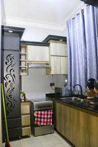 una cucina con frigorifero in acciaio inox e lavello di FirstChoice apartments Kampala a Kampala Altre 4 foto