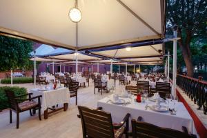 a restaurant with tables and chairs under a tent at Kremlin Palace in Lara