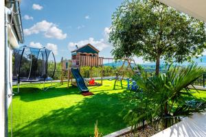 a playground with a slide and a swing at Villa La Meravigliosa in Vodice