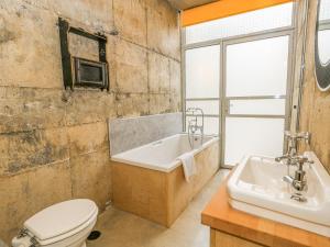 a bathroom with a tub and a toilet and a sink at Standby Generator Bunker in Dorchester +59 photos