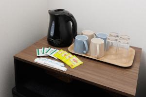 a table with a tea kettle and cups on it at Wright Style ANNEX in Naoshima