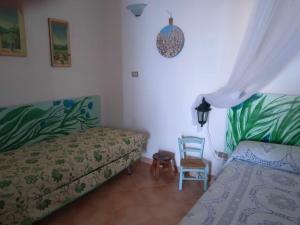 a bedroom with a bed and a chair in it at le case dei fiori in Pisciotta
