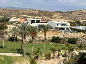 ein Haus mit Palmen vor einem Berg in der Unterkunft ViveVera - Chalet Palmera Golf Valle del Este in Vera