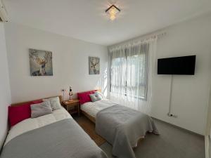 ein Schlafzimmer mit zwei Betten und einem Flachbildfernseher in der Unterkunft ViveVera - Chalet Palmera Golf Valle del Este in Vera