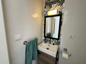 ein Badezimmer mit Waschbecken und Spiegel in der Unterkunft ViveVera - Chalet Palmera Golf Valle del Este in Vera + 12 Fotos