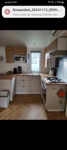 Una cocina con gabinetes blancos y un horno de estufa. en Mobil home azur 74, en Fréjus