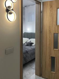 a door leading to a bedroom with a bed at Vista apartment 4 in Choszczówka