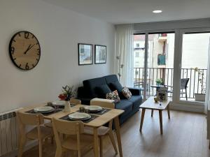 a living room with a table and a clock on the wall at Vivienda turística El Caminante con garaje in Soria