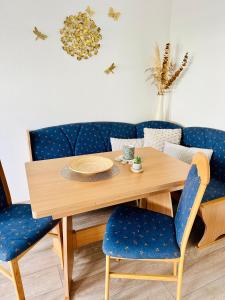 a dining room table with blue chairs and a wooden table at Ferienwohnungen Dörte & Stella Hof Saale in Hof +18 photos
