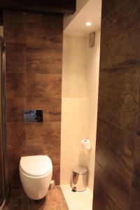 a bathroom with a toilet and a wall at Loft Niezapominajka w Tobaco Park in Łódź +26 photos