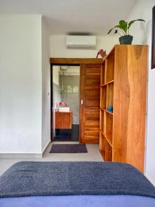 a bedroom with a bed and a bathroom with a sink at Villa Pandan Simeulue in Salul