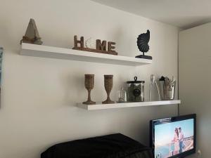 a living room with shelves on the wall and a television at Heritage in Oasis Resort Lozenets in Lozenets