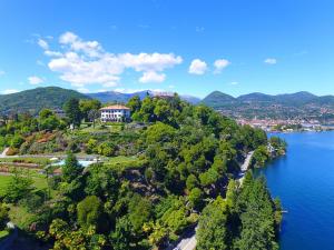 a house on top of a hill next to a body of water at Villino San Remigio - Gracious villa with pool & views! in Verbania