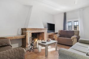 a living room with a fireplace and a tv at Casa Pilar in Ronda
