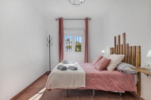 a bedroom with a bed with pink sheets and a mirror at Casa Pilar in Ronda +23 photos
