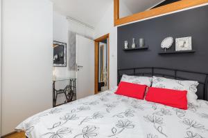 a bedroom with a bed with two red pillows at Holiday Home Doda in Fažana - 100 m from the Sea in Fažana